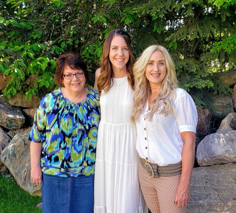 Three of the stylists from Total E'Clips Salon in Smithfield, Utah, standing together outdoors